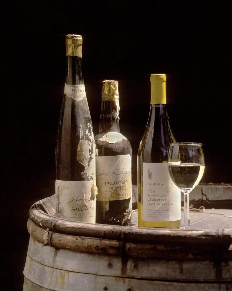 A bottle of CHARDONAY from the PAGE MILL WINERY is accompanied by an 1889 bottle from the defunct PALO ALTO VINEYARD  - Wine Industry photography by Craig Lovell
