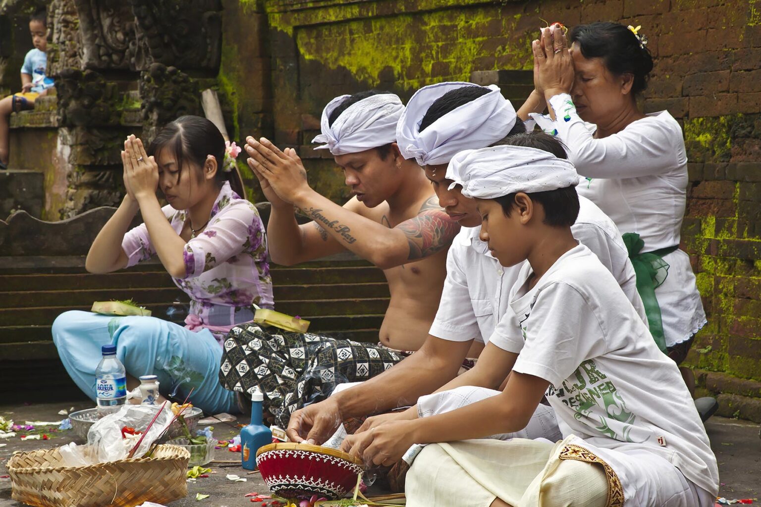 A BALINESE family prays at PURA TIRTA EMPUL a Hindu Temple complex and cold springs with healing waters - TAMPAKSIRING, BALI, INDONESIA