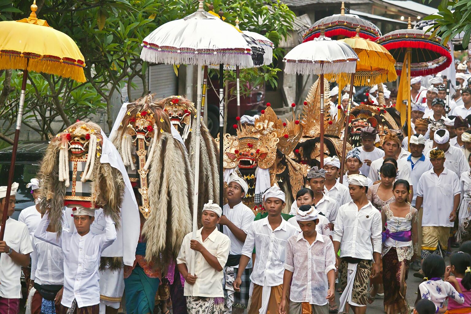 A BARONG COSTUME and LION MASKS used in traditional LEGONG dancing are carried during a HINDU PROCESSION for a temple anniversary - UBUD, BALI