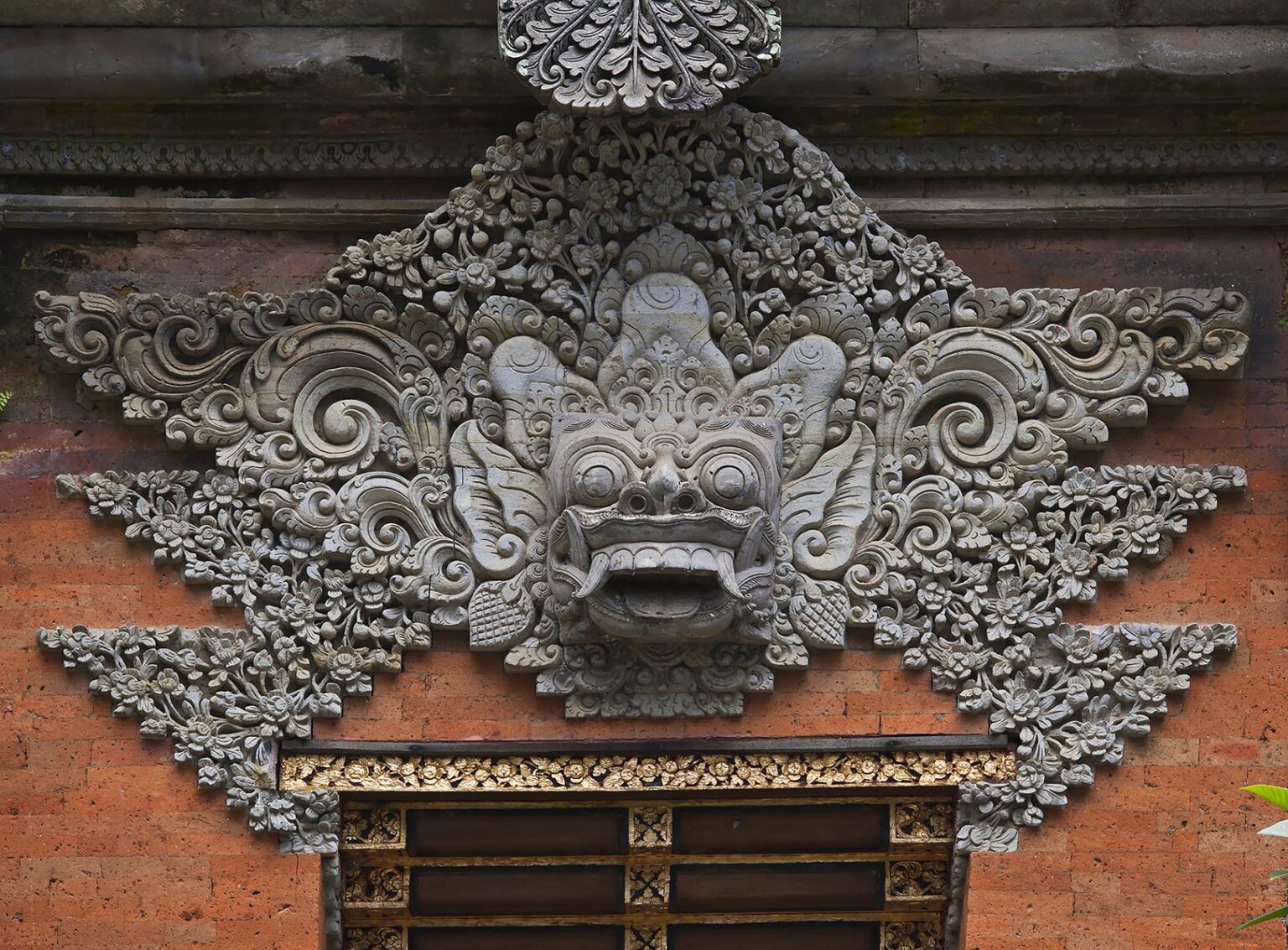 Ornate hand carved stone gate with Barong face of PURA DESA UBUD, the main Hindu temple of the town - UBUD, BALI