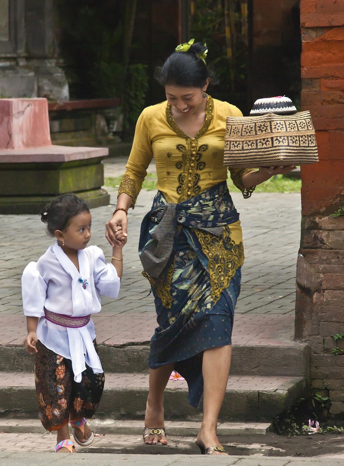 BALINESE woman and daughter carry offerings intothe Hindu temple of PURA DESA during the GALUNGAN FESTIVAL - UBUD, BALI, INDONESIA