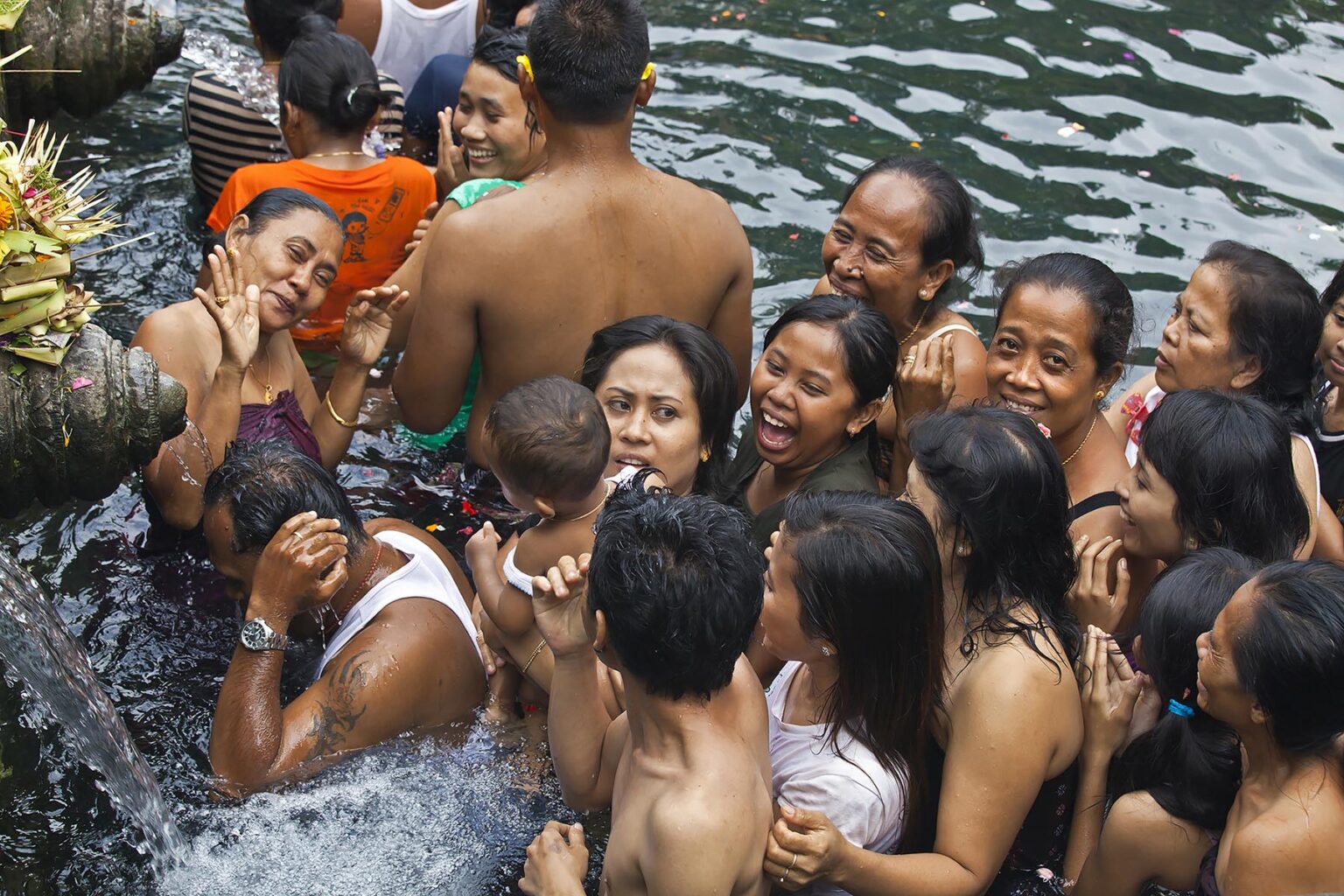 People bath in the holy waters of the cold spring at the PURA TIRTA EMPUL TEMPLE COMPLEX during the Galungan Festival -  TAMPAKSIRING, BALI, INDONESIA