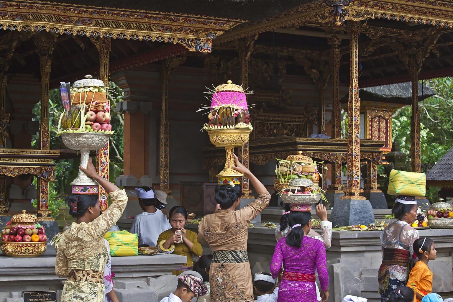 Women bring offerings of fruit, flowers and pastries to the PURA TIRTA EMPUL TEMPLE COMPLEX during the GALUNGAN FESTIVAL - TAMPAKSIRING, BALI, INDONESIA