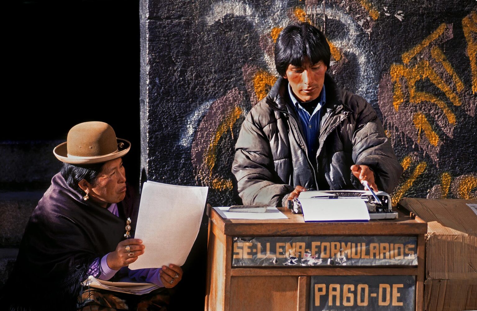 Street scribe types a letter for an illiterate AYMARA woman - LA PAZ, BOLIVIA
