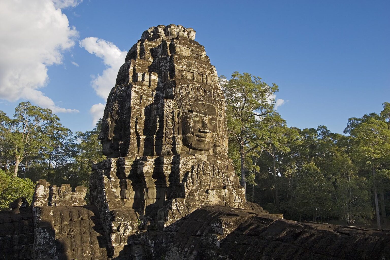 A face tower of The Bayon at Angkor Thom, the largest Khmer city ever built, are part of the Angkor Wat complex - Siem Reap, Cambodia