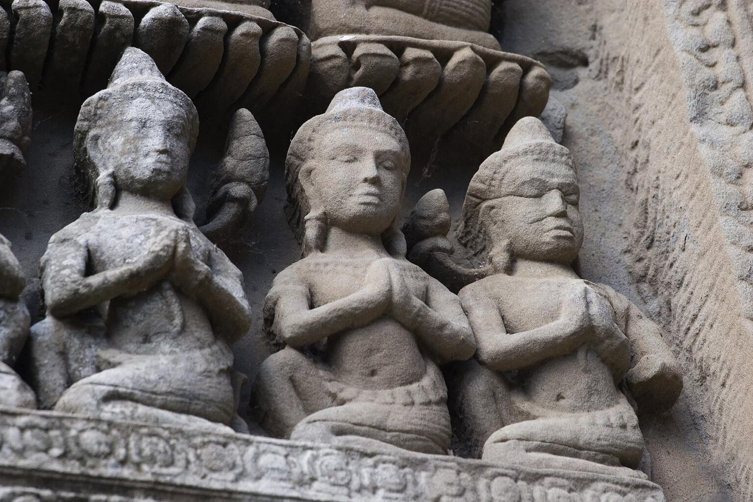 Three bas relief figures in prayer carved on the central Temple representing Mount Meru at Angkor Wat, built in the 11th century by Suryavarman the 2nd - Cambodia