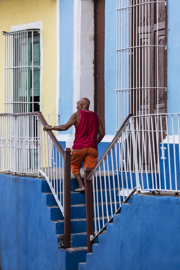 A man walks up stairs along the street - TRINIDAD, CUBA