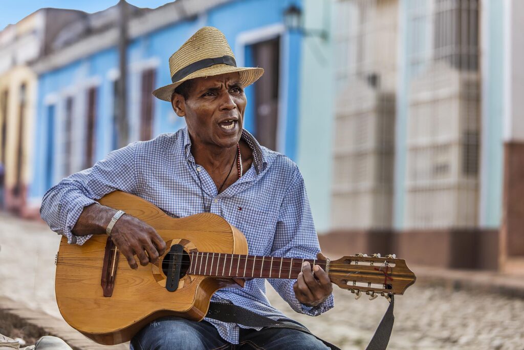 A CUBAN man plays traditional music on his guitar - TRINIDAD, CUBA