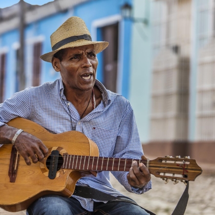 A CUBAN man plays traditional music on his guitar - TRINIDAD, CUBA
