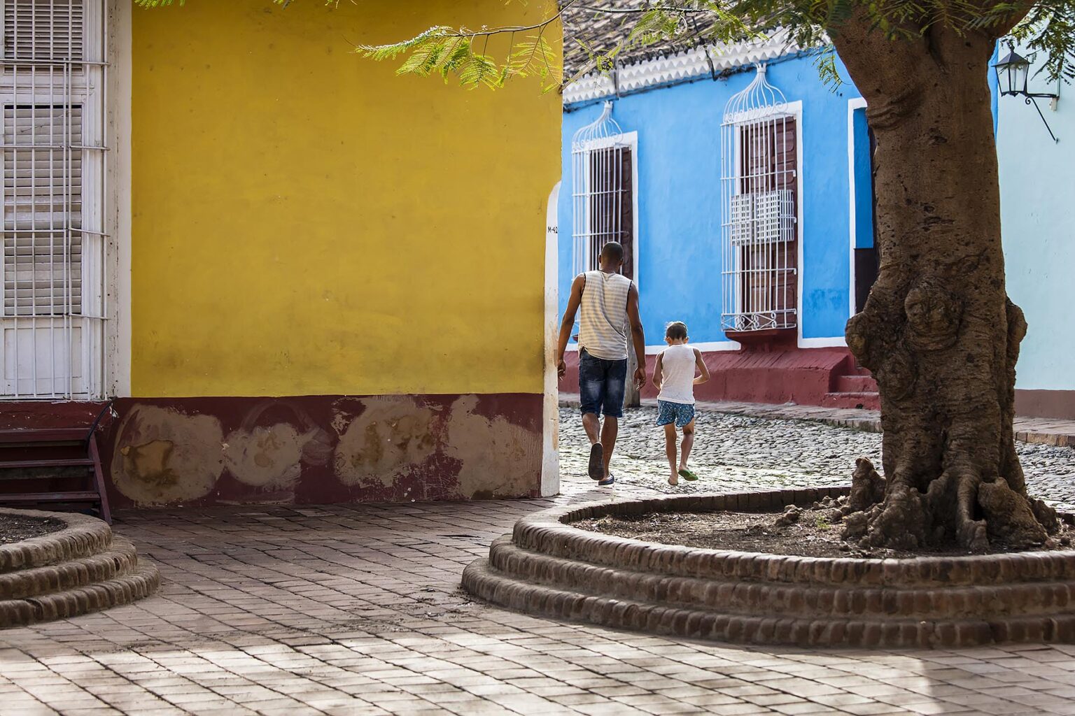 A father and son walking on the cobble stone streets - TRINIDAD, CUBA