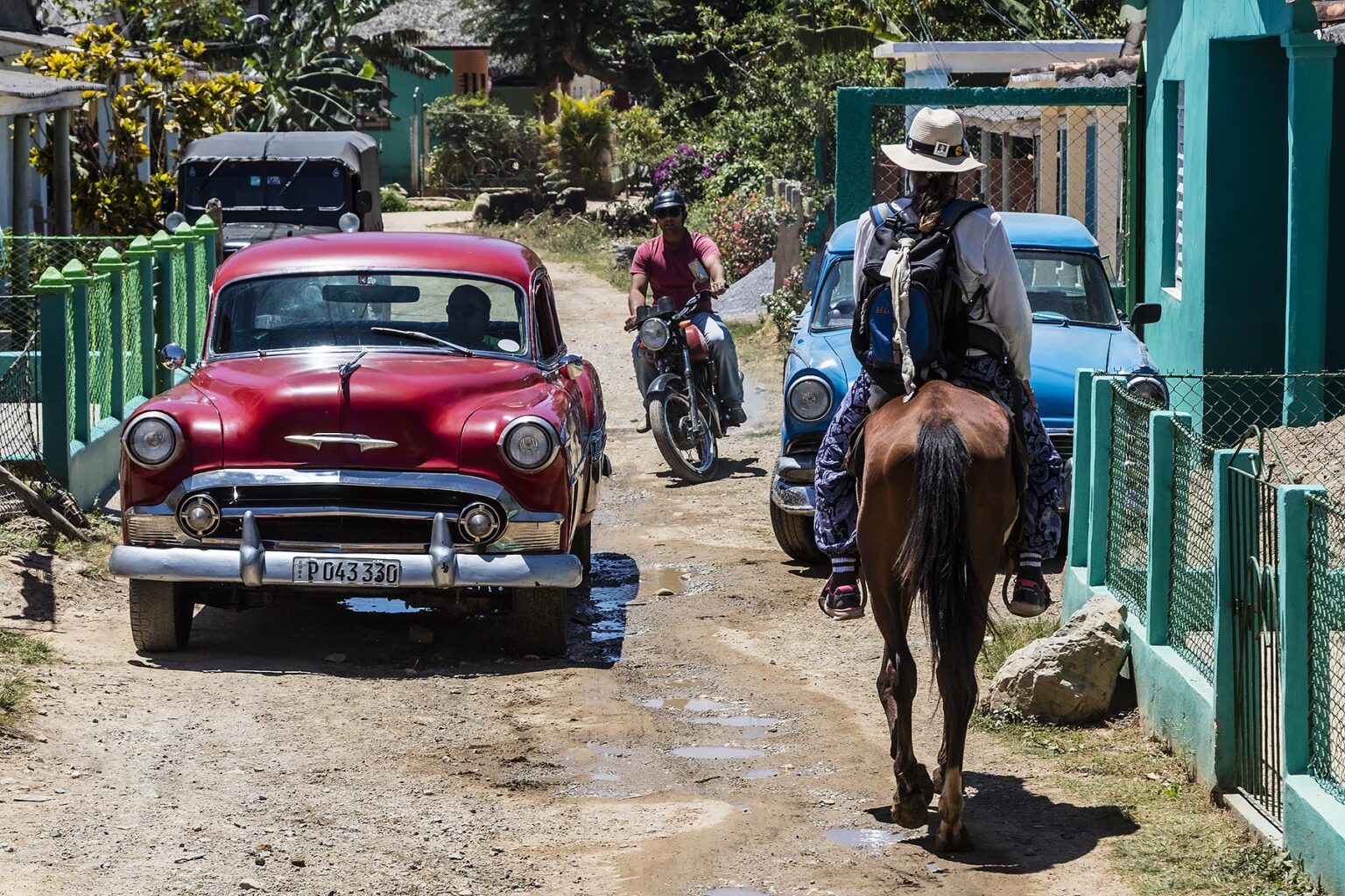Vintage cars and horses share the road on a tour of the Vale de Silencio - VINALES, CUBA