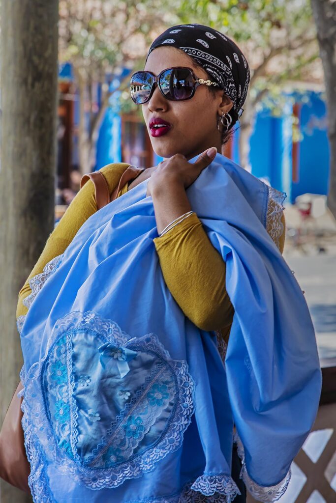 A fashionable Cuban woman looks at a blanket - VINALES, PINAR DEL RIO, CUBA