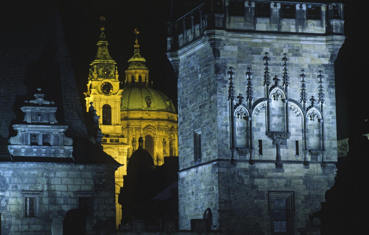 ST. NICHOLAS CHURCH is seen through the TOWER OF CHARLES BRIDGE in historic PRAGUE - CZECH REPUBLIC