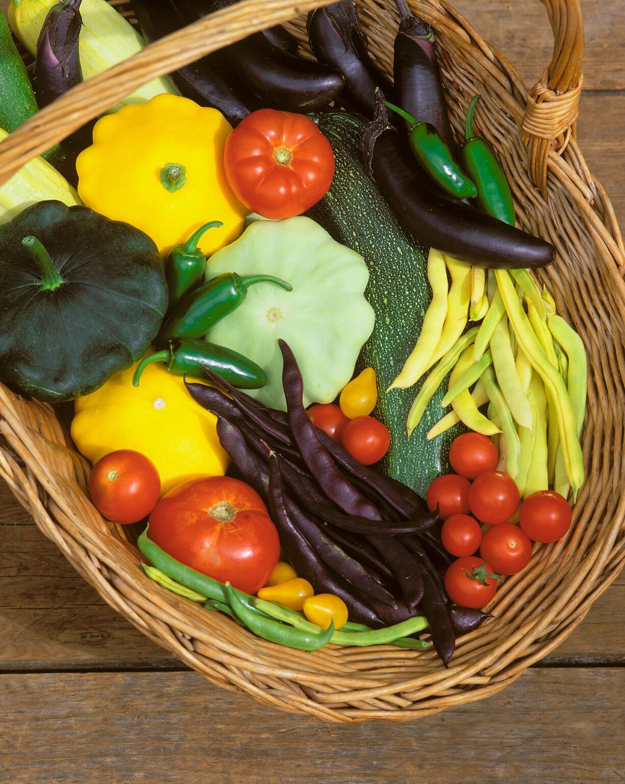 A basket of VEGETABLES - Tomatoes, yellow green Summer Squash, Zucchini, Egg Plant, Peppers, green, yellow and purple Beans
