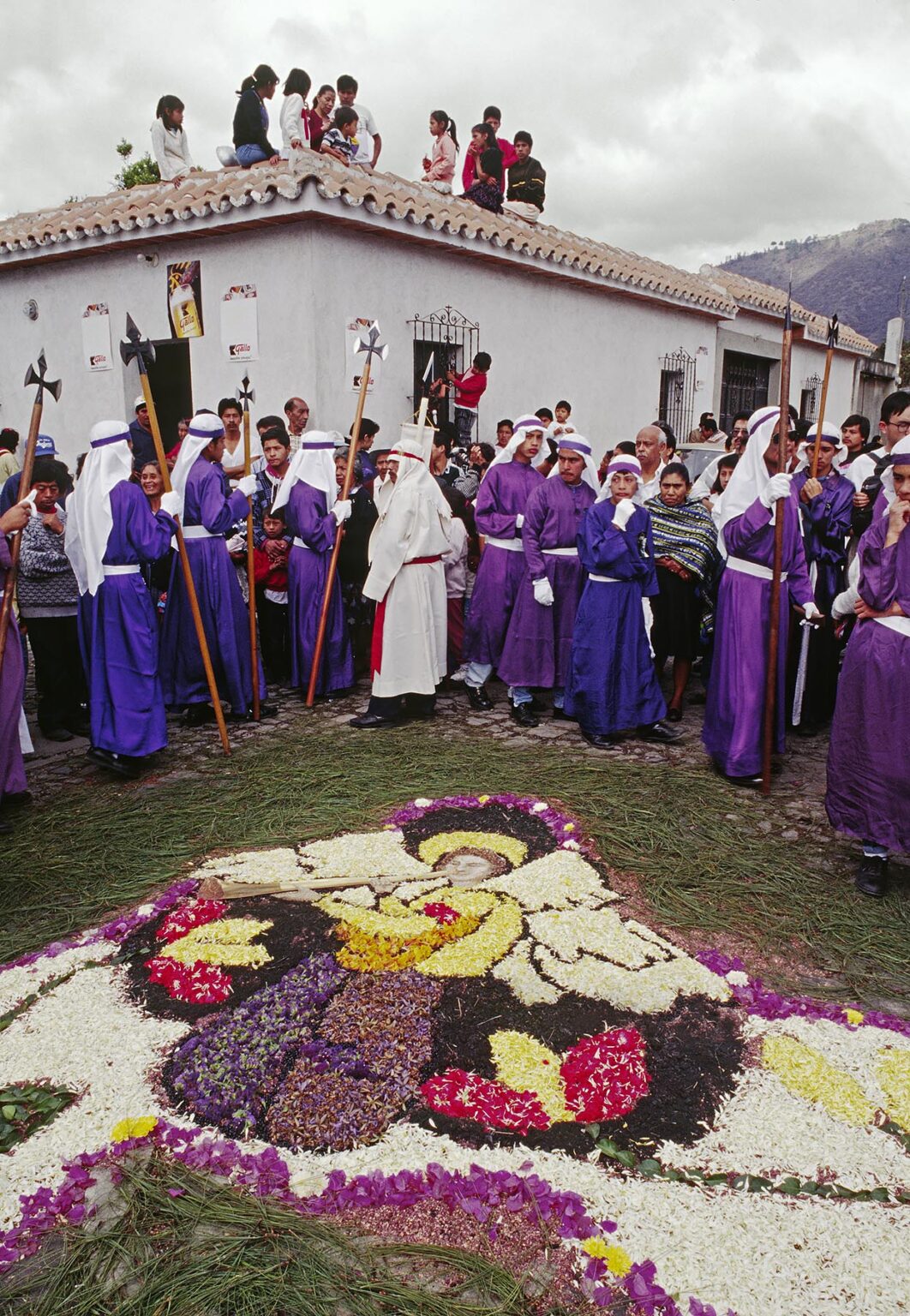 Purple-robed PENITENTS and ANGEL ALFOMBRA (carpet) made of sawdust and flowers for GOOD FRIDAY - ANTIGUA, GUATEMALA