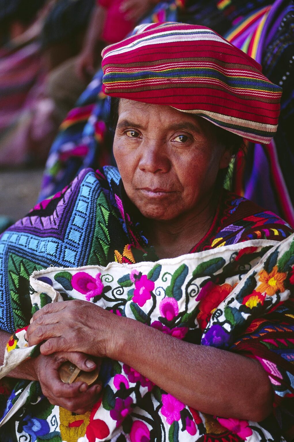 MAYAN WOMAN wearing traditional brocade HUIPILS in MARKETPLACE - CHICHICASTENANGO, GUATEMALA