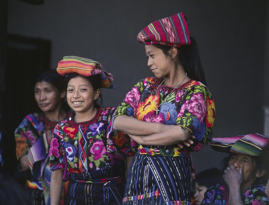 GUATEMALAN WOMEN of MAYA descent wearing traditional brocade HUIPILS - CHICHICASTENANGO, GAUTEMALA