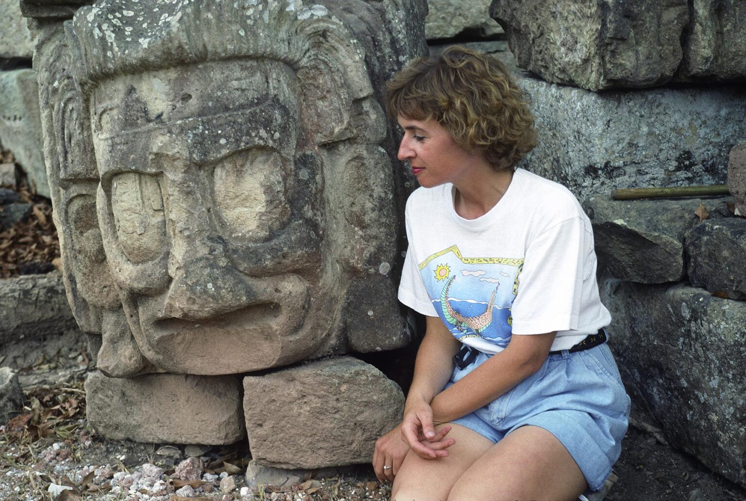 TOURIST with ancient MAYAN stone head, probably a god or ruler, found at the COPAN RUINS - HONDURAS