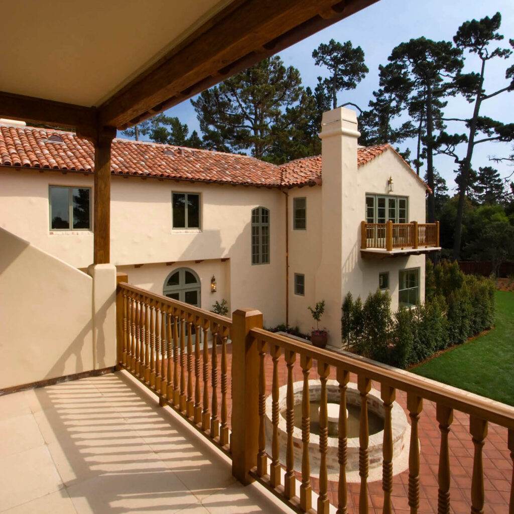 Exterior of a SPANISH STYLE CALIFORNIA LUXURY HOME with large red tiled PATIO as seen from upstairs deck. - Professional photography by Eagle Visions Photography