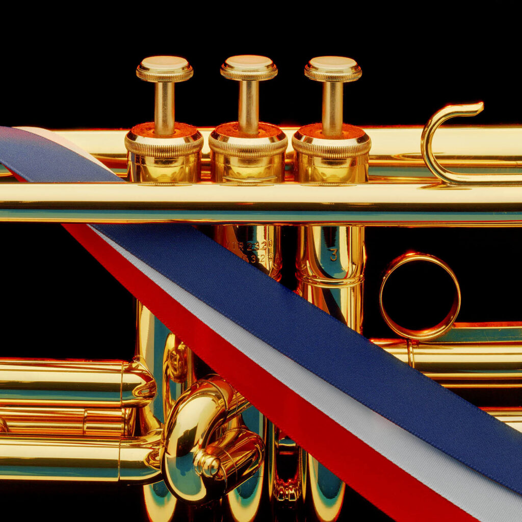 A studio shot of a trumpet detail and the colors of the American flag.  Studio product photography by Craig Lovell