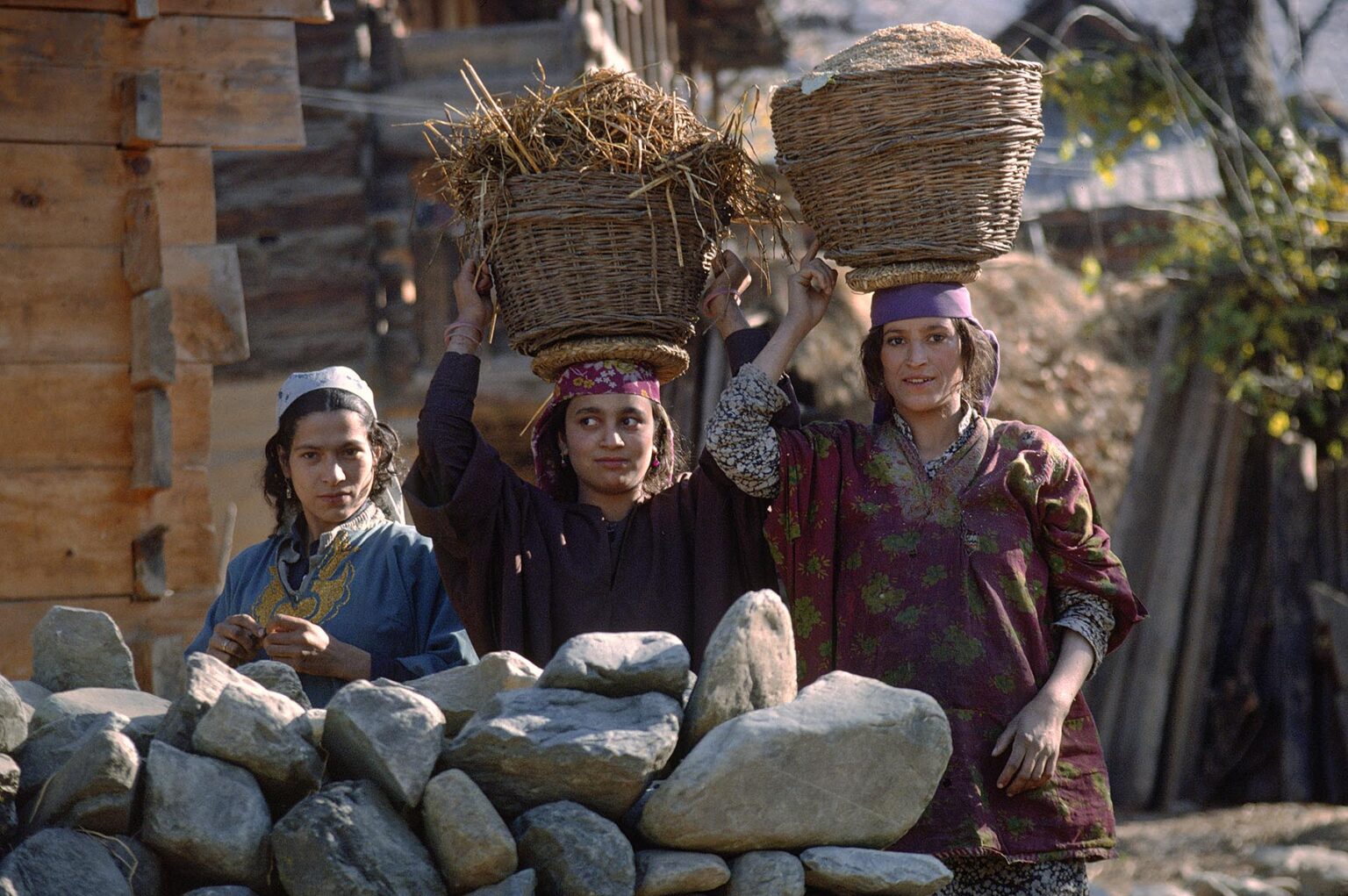 KASHMIRI WOMEN carry BASKETS of grain and dried grass on their heads - KASHMIR, INDIA