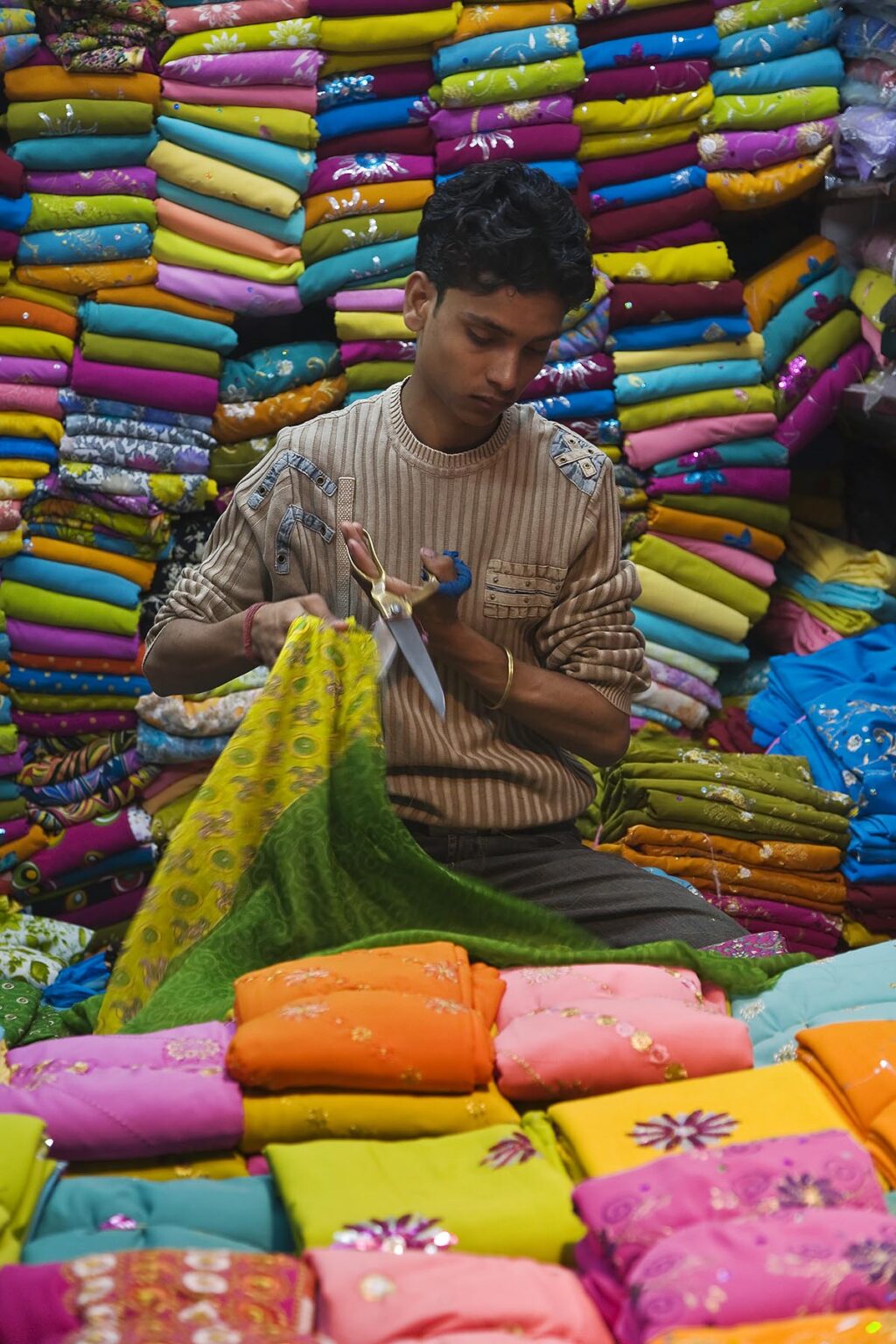 A man works in a stall in the SARI MARKET of CHANDNI CHOWK - OLD DELHI, INDIA