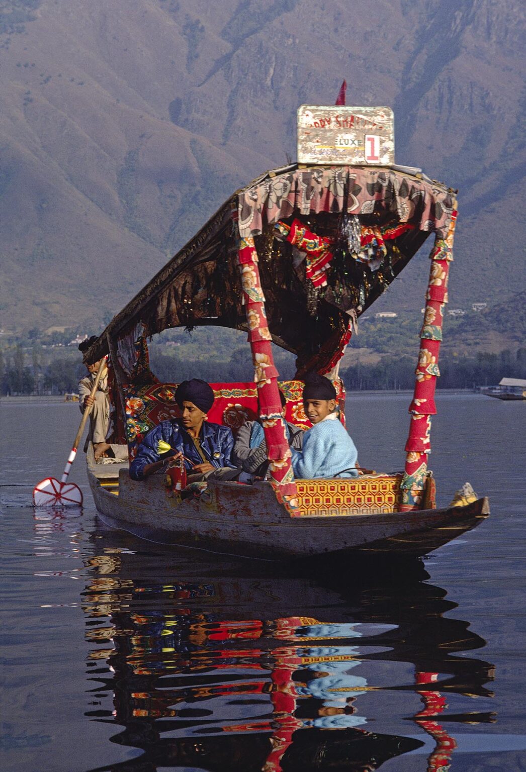 INDIAN TOURISTS take a ride in a SHIKARA, local paddle boat with a canopy, on DAL LAKE in SRINIGAR - KASHMIR, INDI