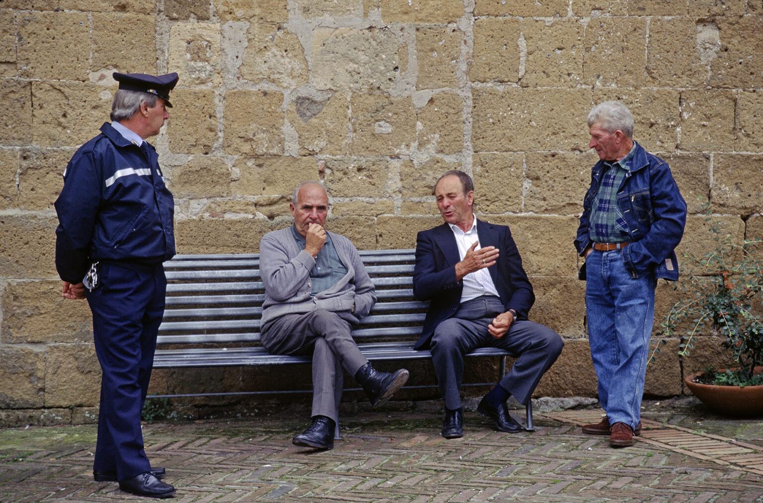 Policeman and local Italians visit in the town of SOVANA (Medieval town recently restored) - TUSCANY, ITALY