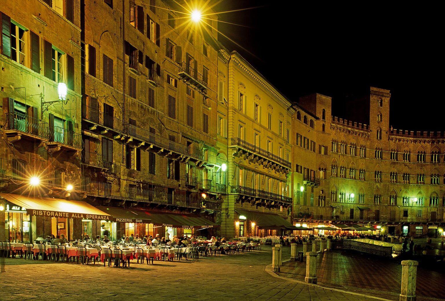 Night shot of restaurants around the CAMPO (central plaza) in the MEDIEVAL city of SIENA - TUSCANY, ITALY
