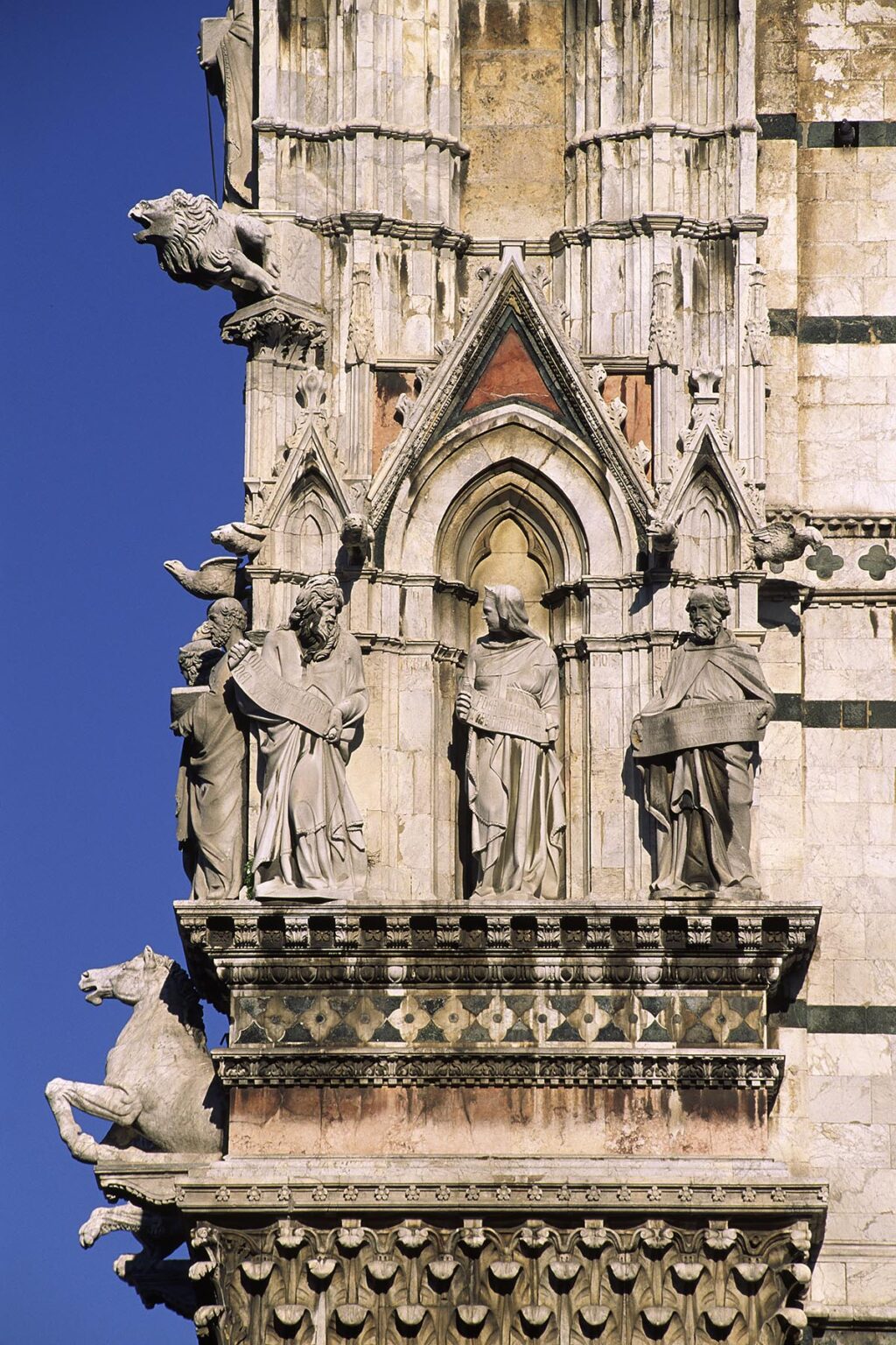 Carved marble Saints and winged Lion & Bull decorate the ornate facade of  SIENA'S CATHEDRAL begun in 1196 AD - TUSCANY, ITALY