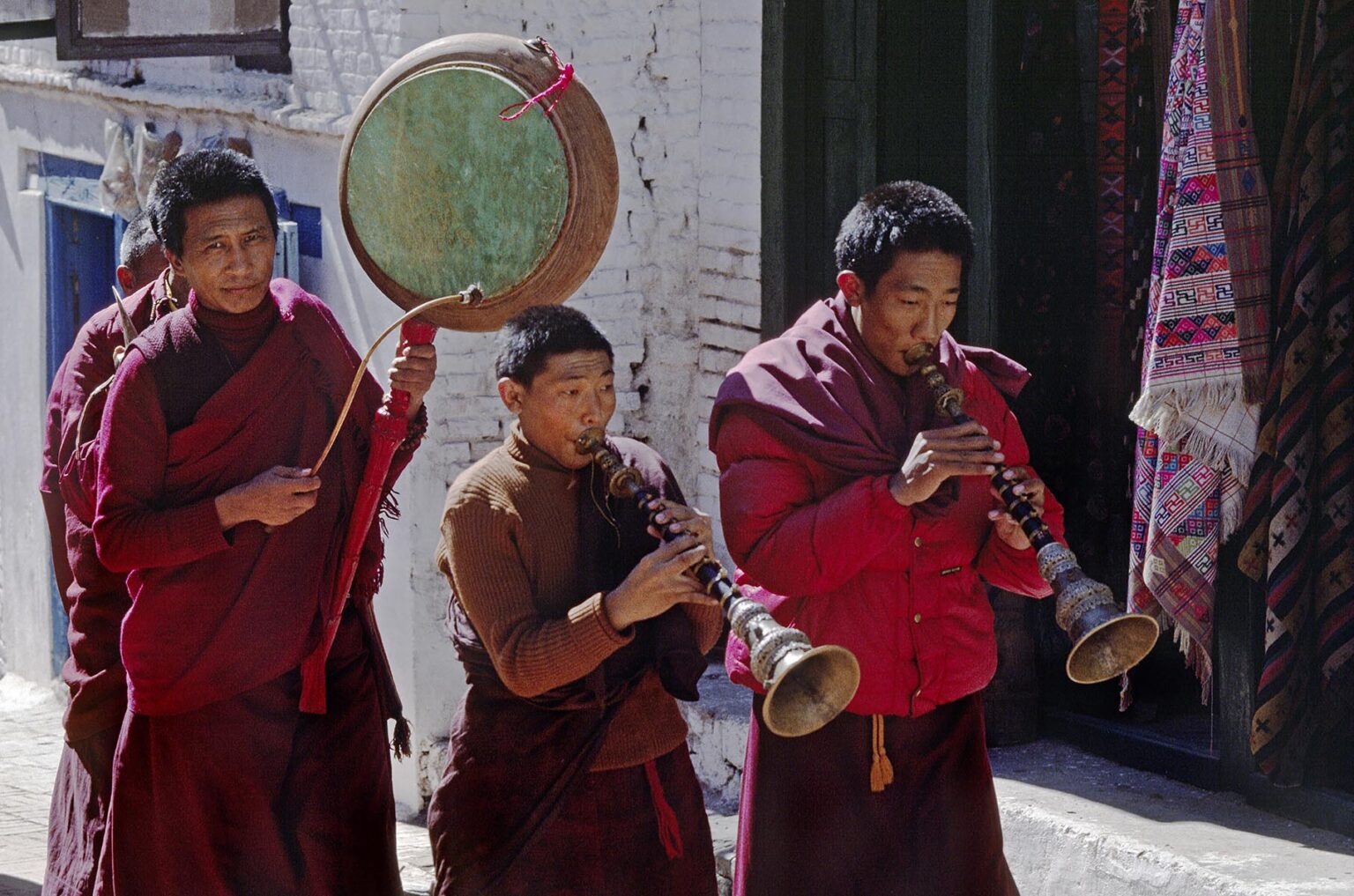 Tibetan Buddhist monks play musical instruments as they parade around Bodhanath Stupa in a religious festival