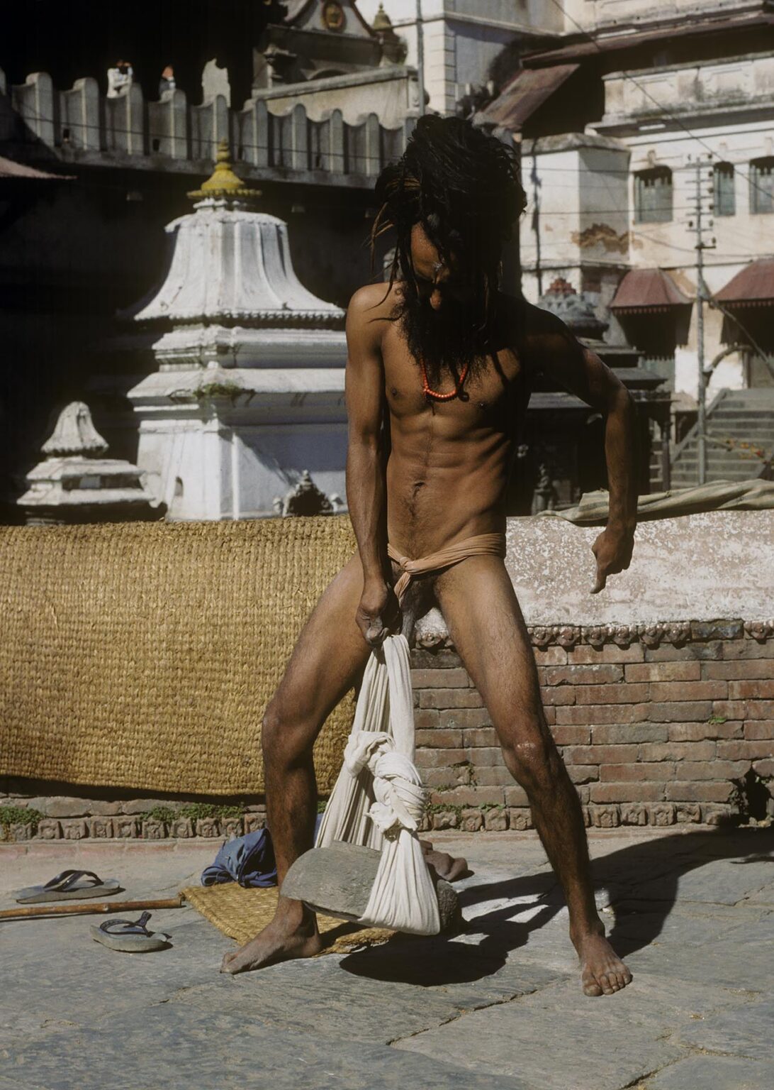 A SADHU (Hindu Renunciate) does a TANTRIC YOGA practice by lifting heavy rocks with his penis at PASHUPATINATH
