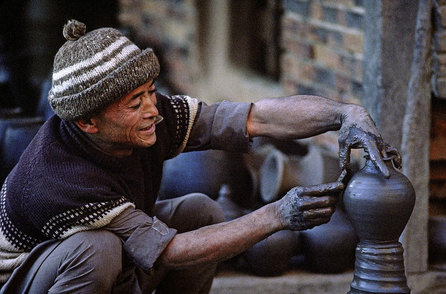 A POTTER is hard at work in the Pottery Bazaar of BHAKTAPUR, NEPAL