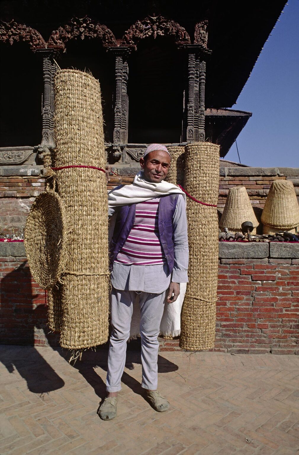 A Nepali man carries hand woven matts - Pattan, Nepal