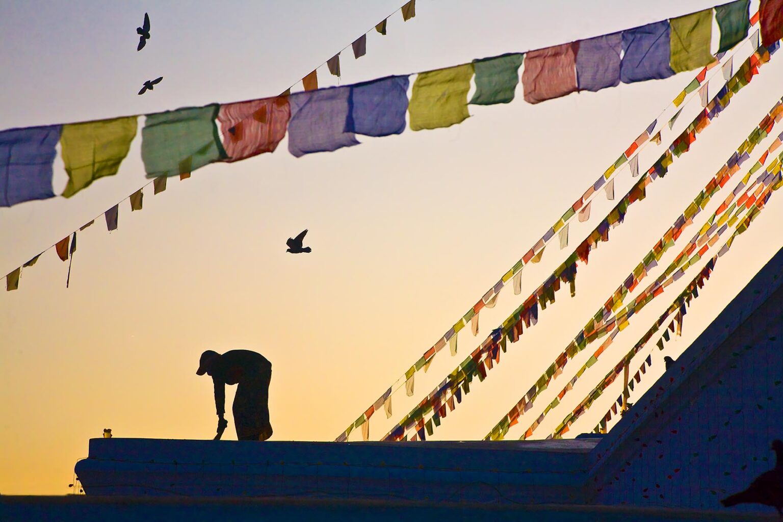 TIBETAN PRAYER FLAGS blow in the breeze at sunrise - BODHANATH STUPA, KATMANDU, NEPAL