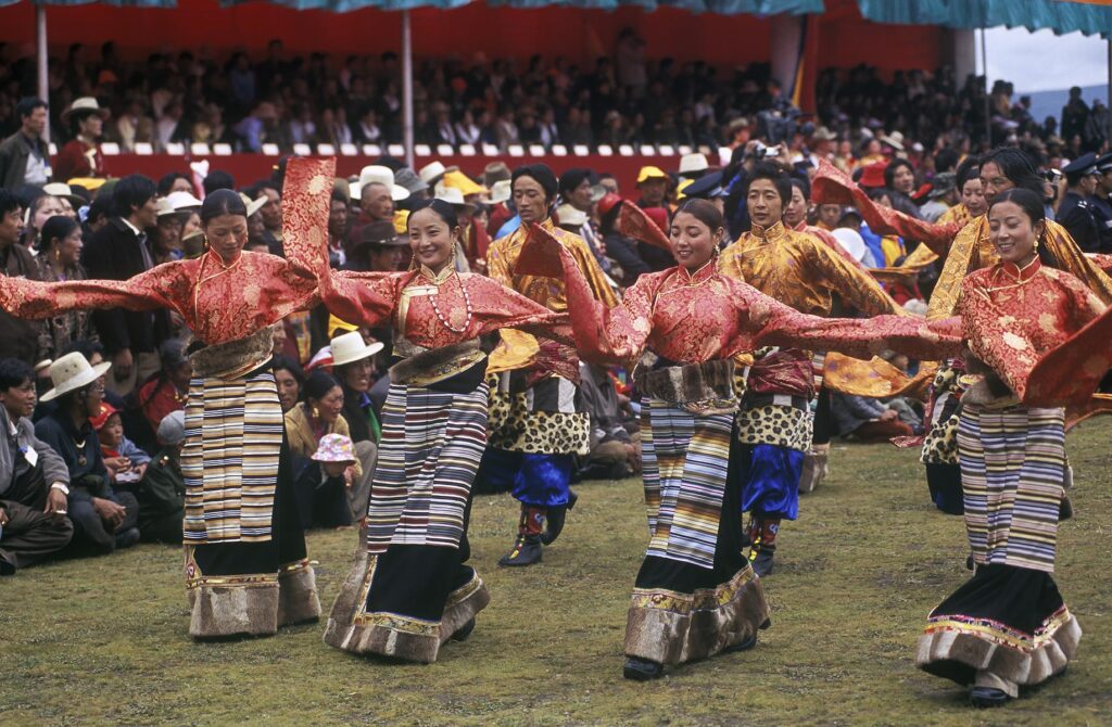 Dance troops preform at the Litang Horse Festival, representing various regions of Kham - Sichuan Province, China, (Tibet)