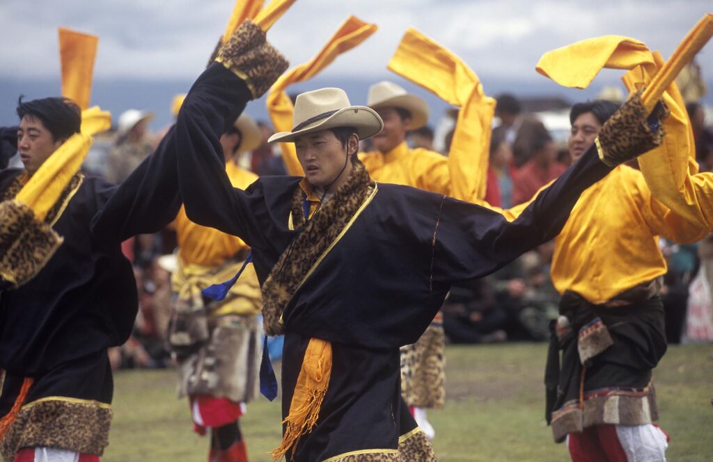 Dance troop with otter skin costumes represent a region of Kham - Litang Horse Festival, Sichuan Province, China