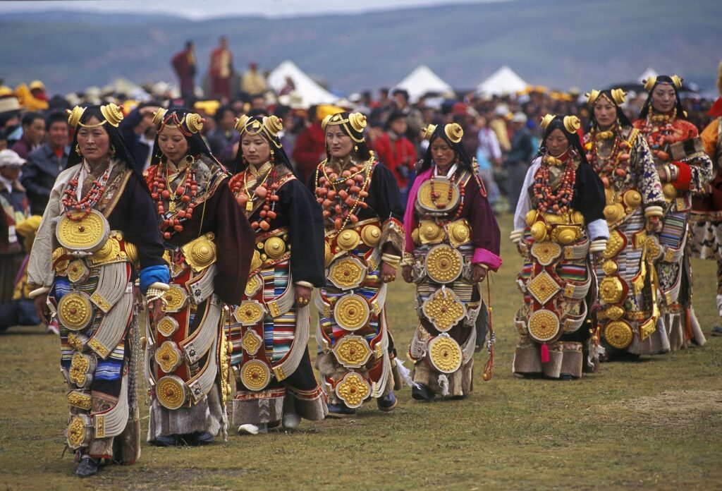 Female Khampa's wear gold hair pieces and gau boxes, zee stones and coral at the Litang Horse Festival - Sichuan Province, China