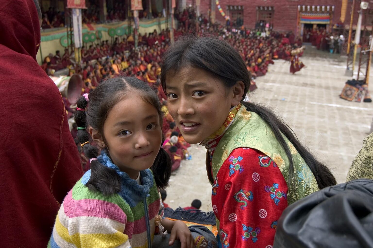 Sisters at the Monlam Chenmo masked dances, Katok Dorjeden Monastery - Kham, (Tibet), Sichuan Province, China