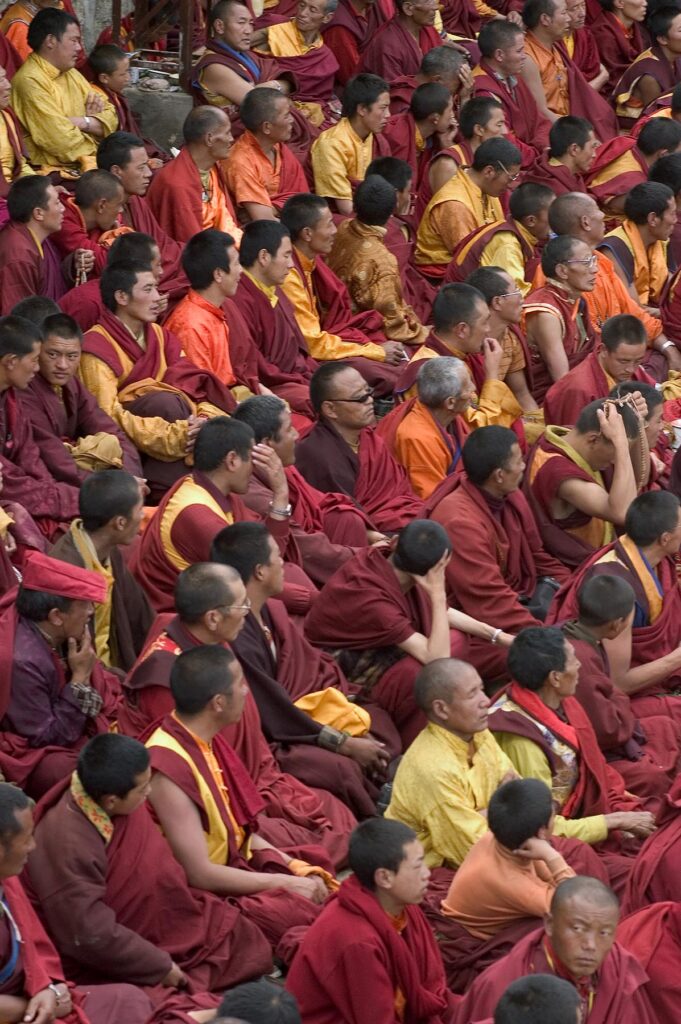Tibetan Buddhist monks of the Nyingma sect at Katok Dorjeden Monastery watch the Cham dances - Kham, (Tibet), Sichuan, China