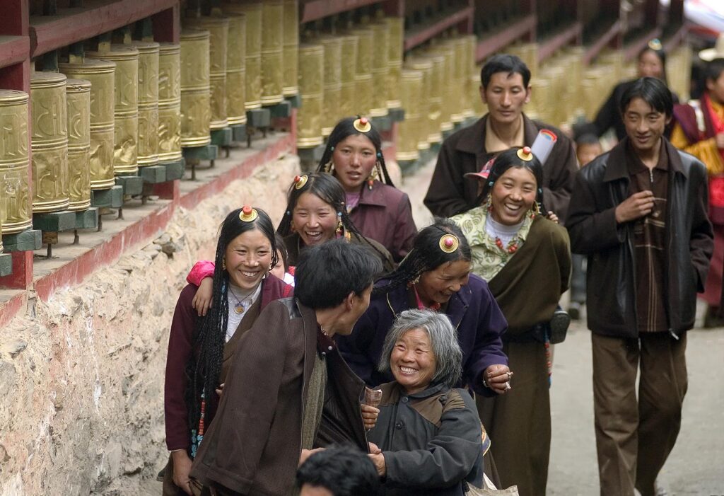 Pilgrims & prayer wheels at the Monlam Chenmo masked dances, Katok Dorjeden Monastery - Kham, (Tibet), Sichuan, China
