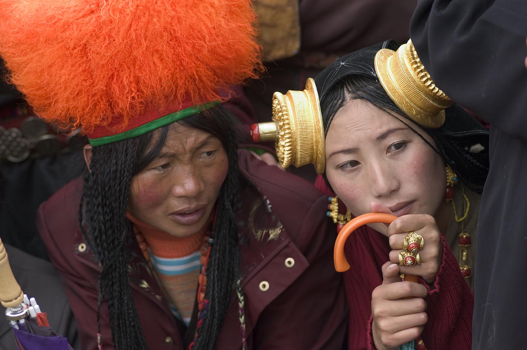 Detail of traditional female Khampa's Orange Fuzzy Hat, wearing gold and coral hair pieces at the Litang Horse Festival - Sichuan Province, China (Tibet)
