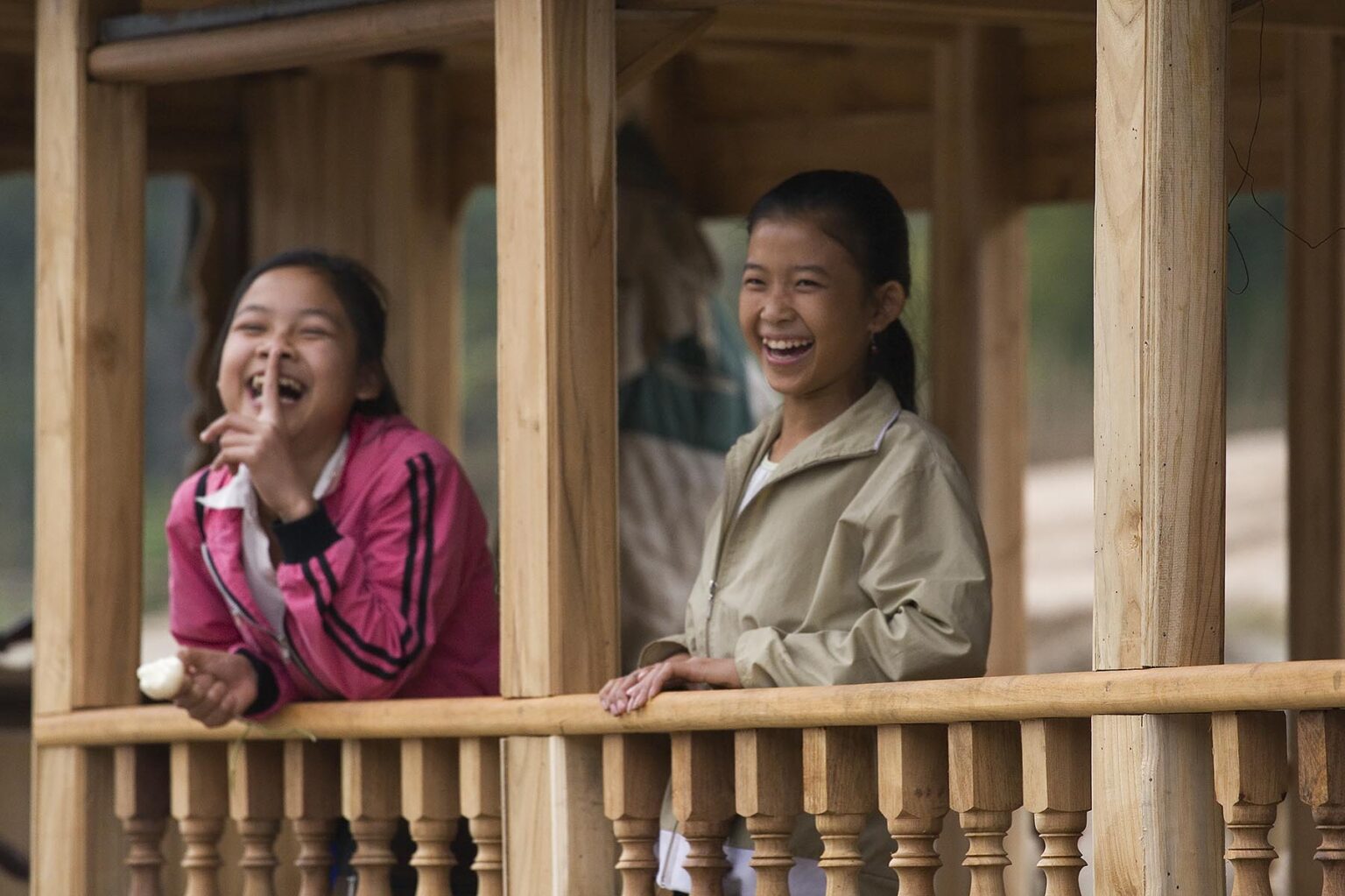 Two young Laotian girls having fun in a houseboat on the Mekong River - LUANG PROBANG, LAOS