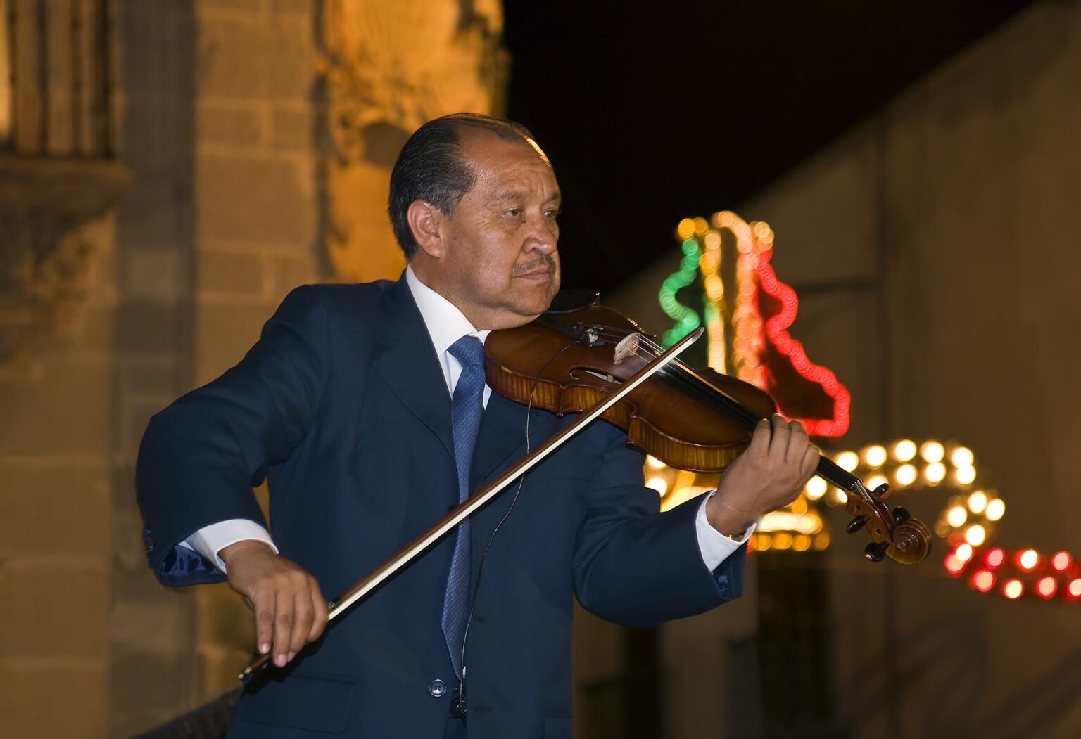 A VIOLINIST preforms in the Central Plaza or Jardin during the Fiesta of San Miguel Archangel held in September - SAN MIGUEL DE ALLENDE, MEXICO