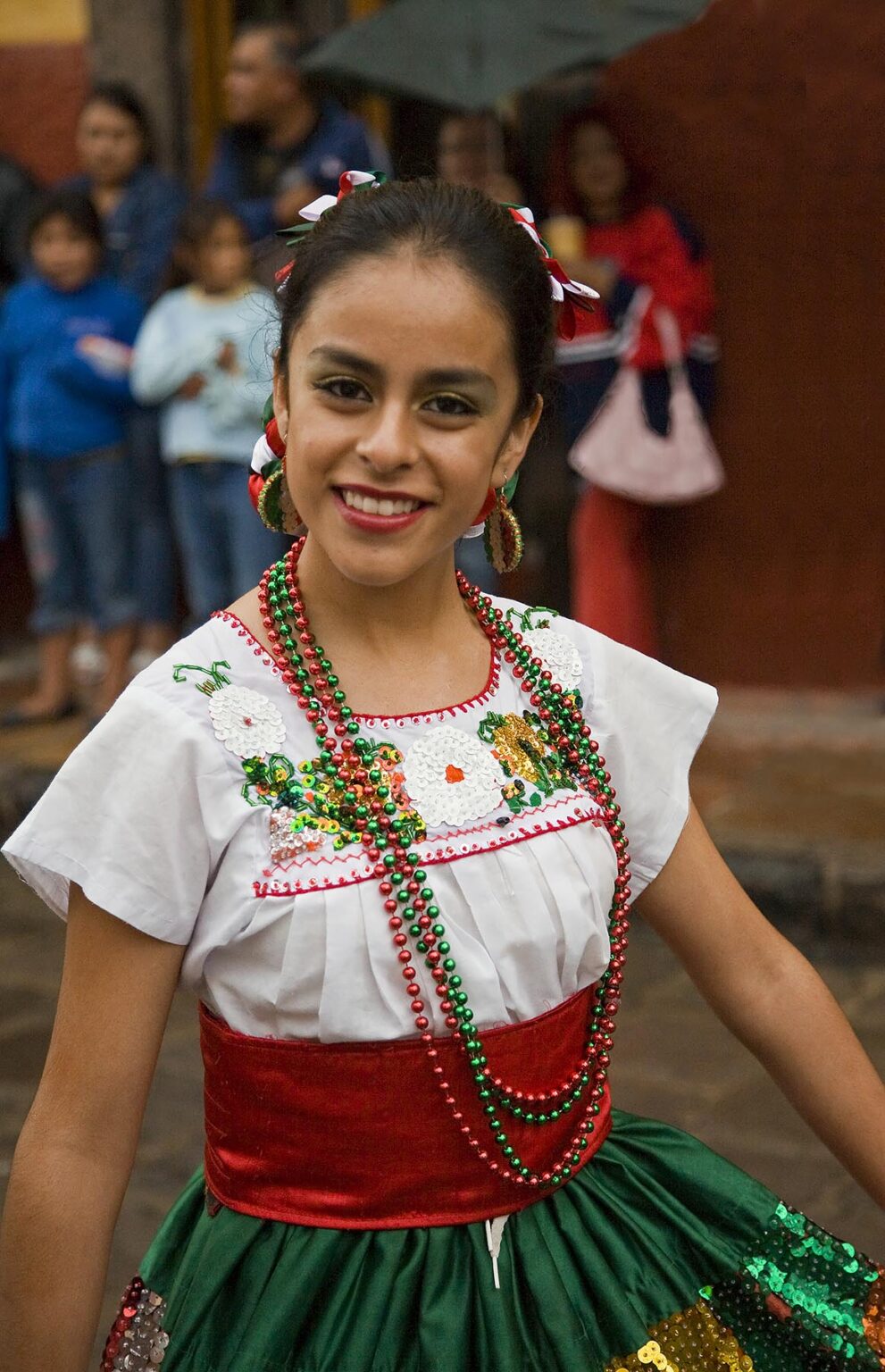 A MEXICAN woman in traditional PEASANT COSTUME walks in the FESTIVAL DE SAN MIGUEL ARCHANGEL PARADE - SAN MIGUEL DE ALLENDE, MEXICO