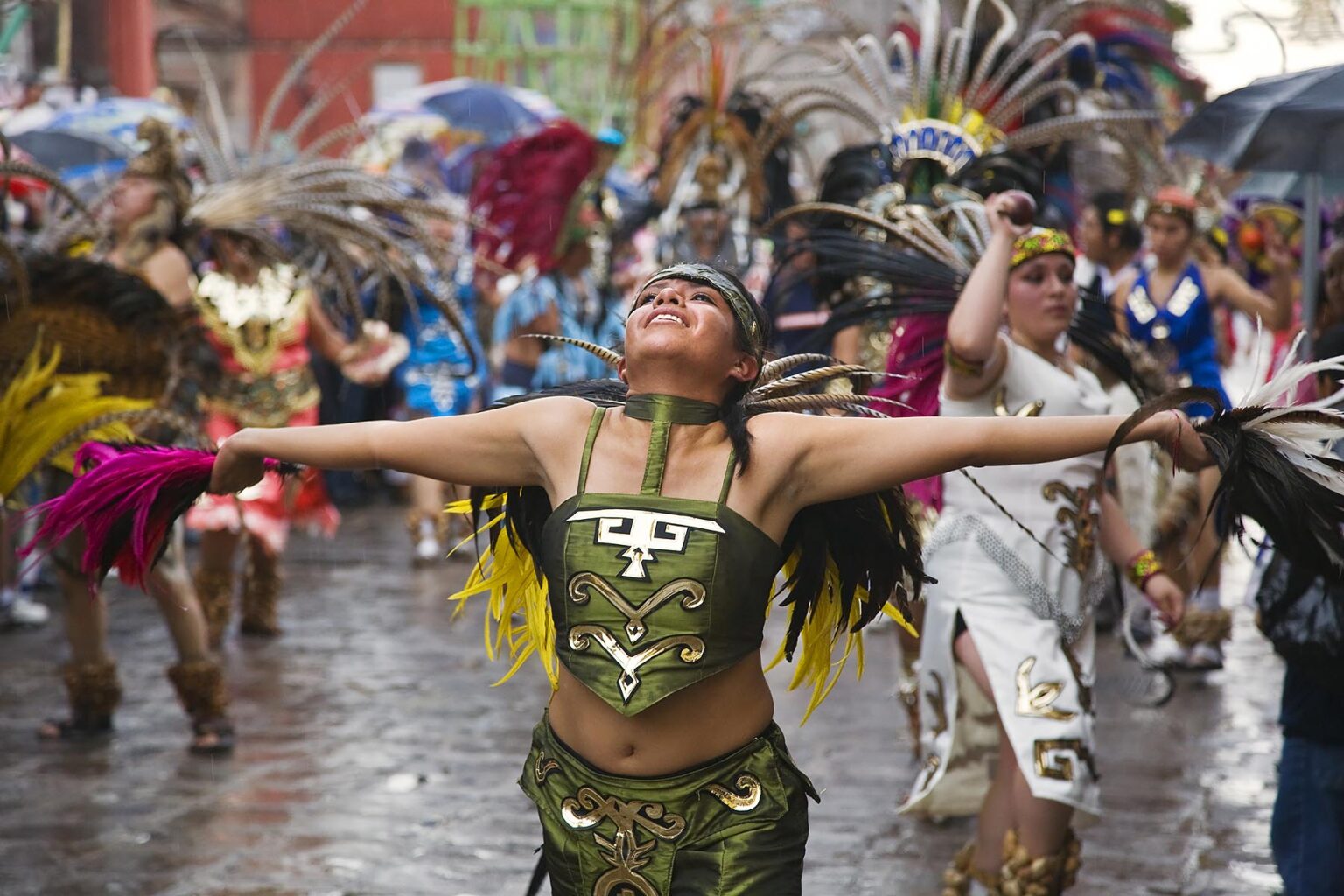 MEXICAN women dance in AZTEC INDIAN COSTUMES & FEATHERED HEADDRESSES in the FESTIVAL DE SAN MIGUEL ARCHANGEL PARADE - SAN MIGUEL DE ALLENDE, MEXICO