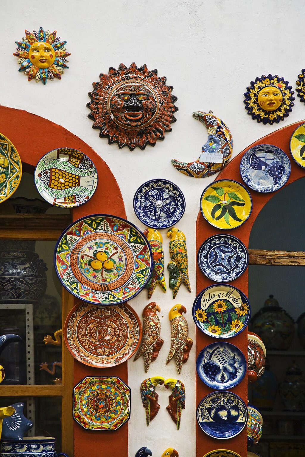 TALEVERA pottery including decorative plates, suns and birds hang in a DOLORES HIDALGO shop - GUANAJUATO, MEXICO