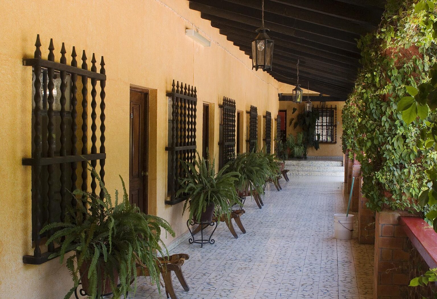 Wrought iron window grates wooden doorways and a covered walkway create the Mexican style of this hotel in SAN MIGUEL DE ALLENDE - MEXICO