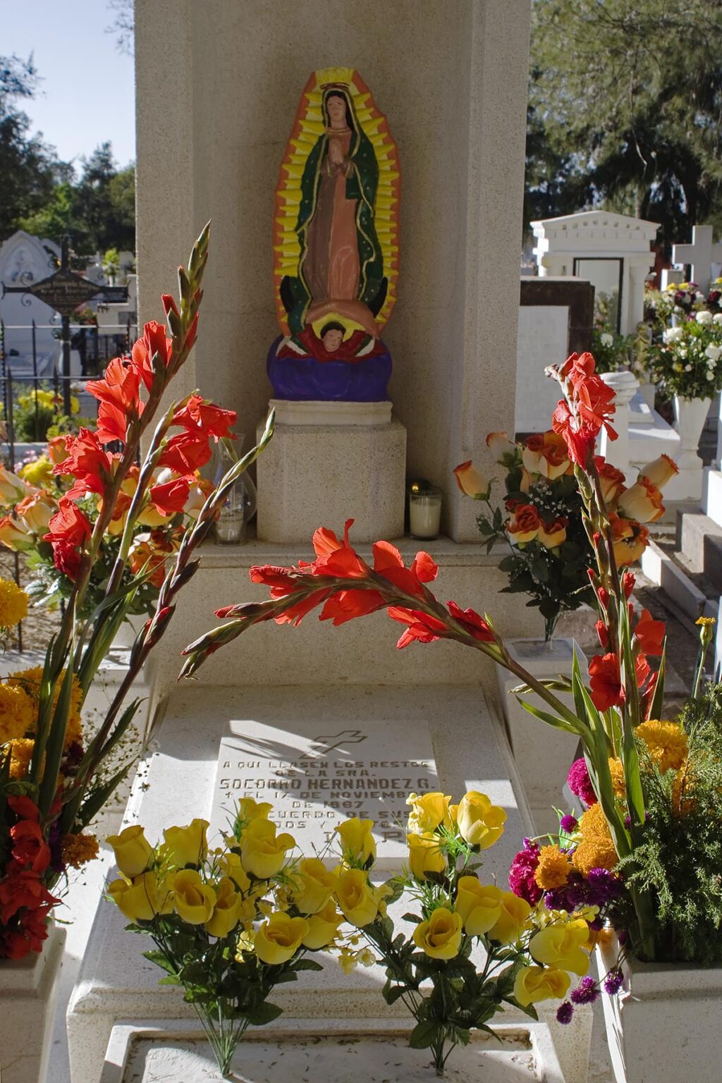 A FLOWER COVERED GRAVE at the local cemetery during the DEAD OF THE DEAD - SAN MIGUEL DE ALLENDE, MEXICO