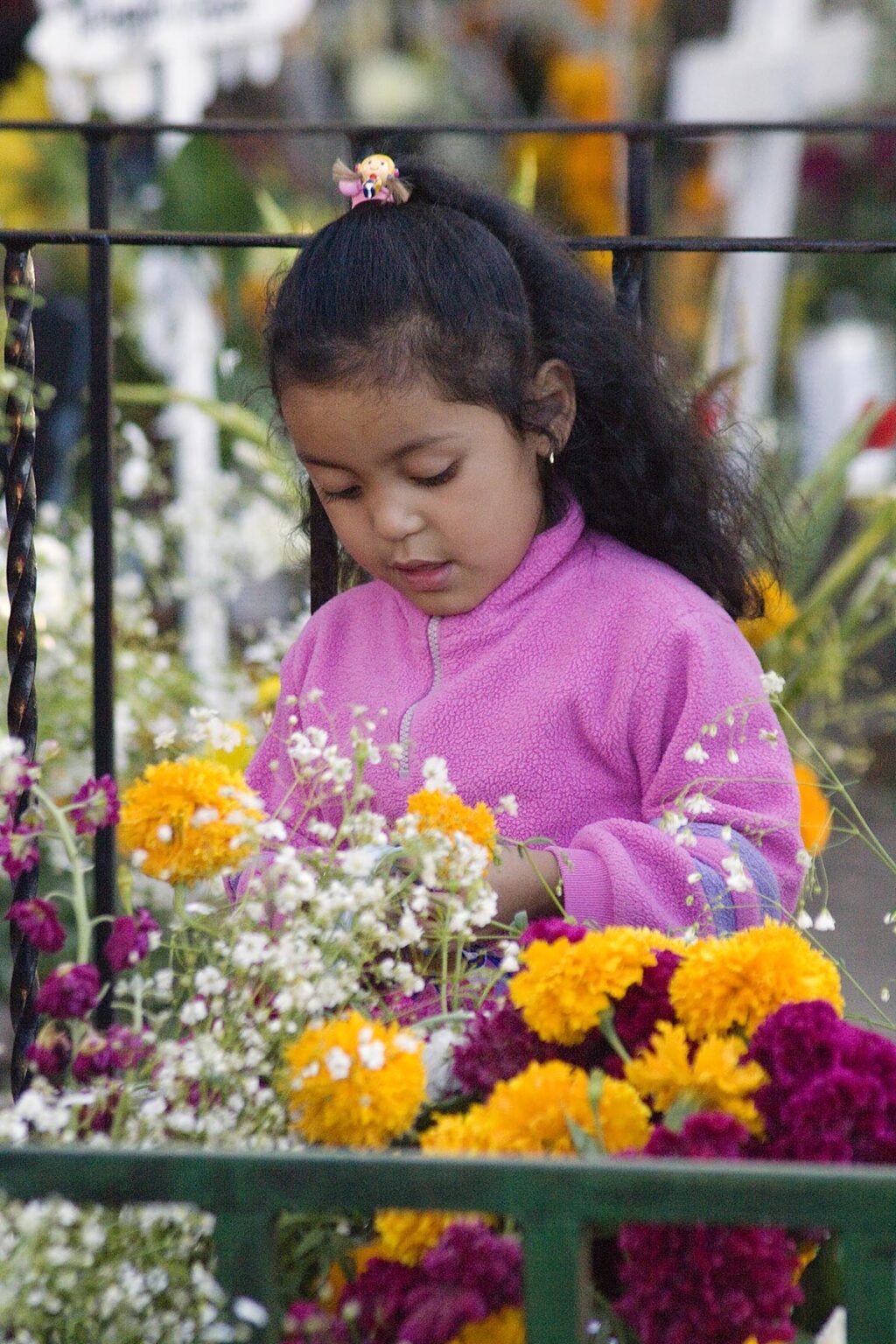 A young MEXICAN girl visits a grave during the DEAD OF THE DEAD - SAN MIGUEL DE ALLENDE, MEXICO